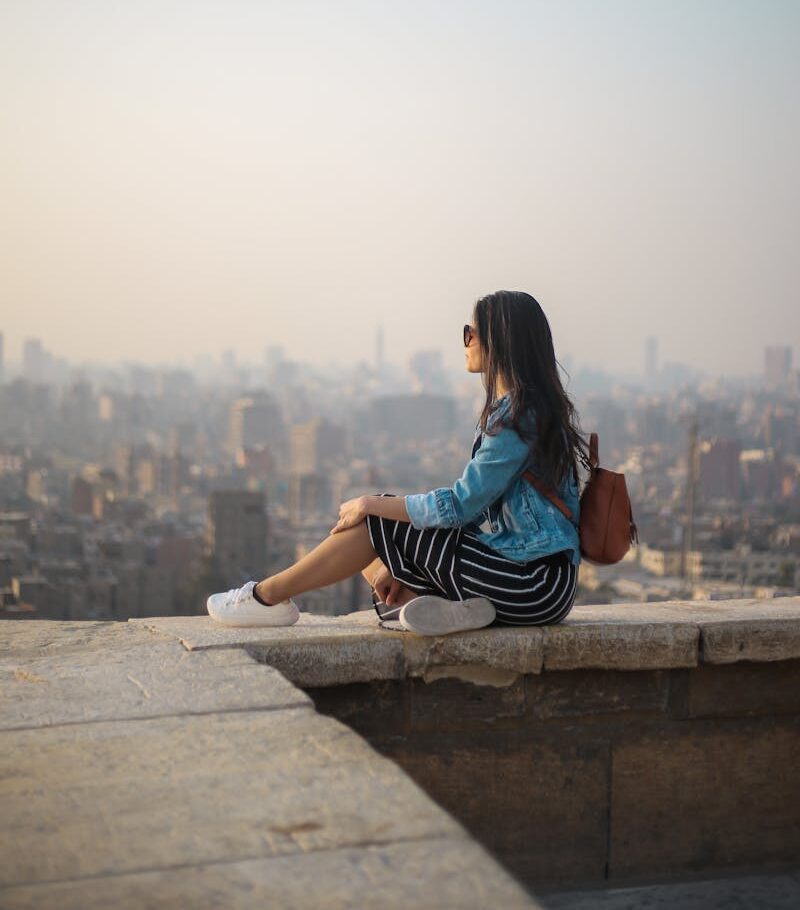 Woman Sitting on Top of Building's Edge